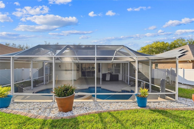 back of property featuring a patio area, fence, a fenced in pool, and a lanai