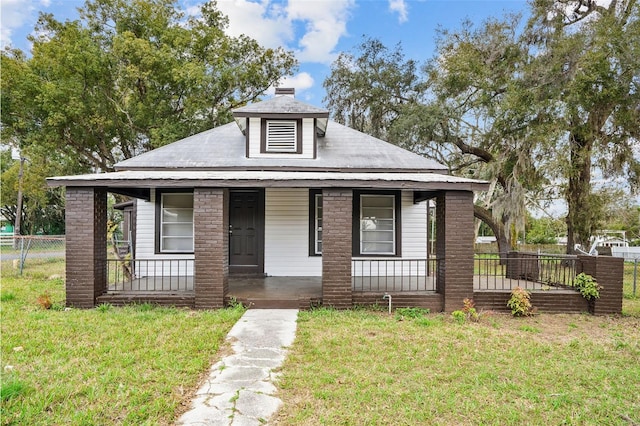 bungalow-style house with a front yard and covered porch