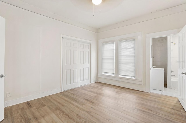 unfurnished bedroom featuring ensuite bath, light hardwood / wood-style floors, and a closet