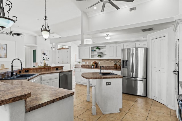 kitchen with sink, decorative light fixtures, a center island with sink, stainless steel appliances, and white cabinets