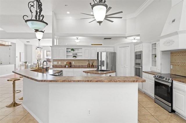 kitchen featuring stainless steel appliances, light tile patterned floors, hanging light fixtures, and white cabinets