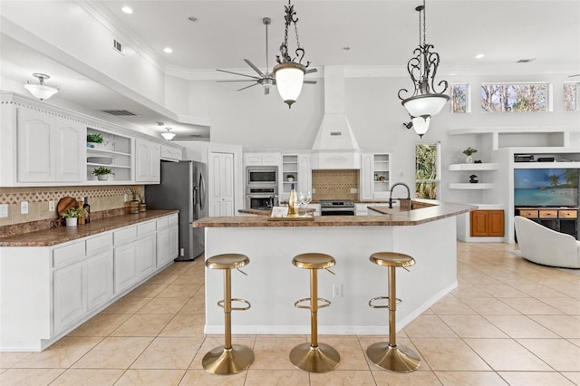 kitchen featuring appliances with stainless steel finishes, white cabinetry, a breakfast bar area, a large island, and light tile patterned floors