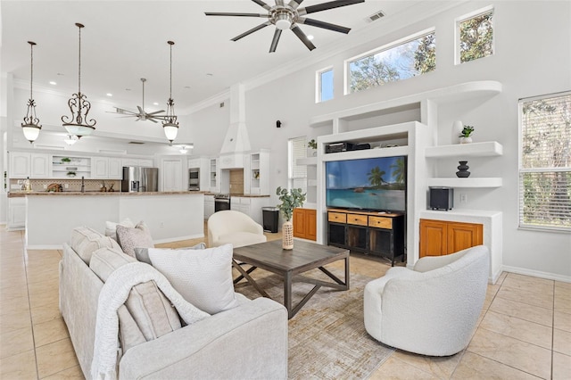 tiled living room featuring crown molding, ceiling fan, and a high ceiling