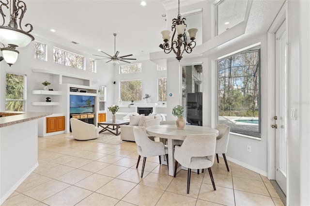 dining room featuring built in shelves, a towering ceiling, light tile patterned flooring, and ceiling fan with notable chandelier