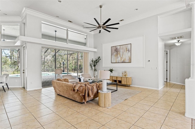 tiled living room with crown molding, ceiling fan, and a towering ceiling