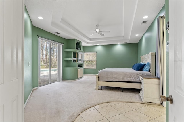 carpeted bedroom with a raised ceiling, access to outside, and ceiling fan