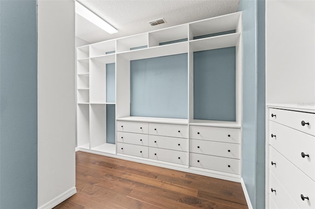 spacious closet with dark hardwood / wood-style floors