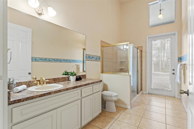 bathroom with vanity, a shower with shower door, tile patterned floors, and toilet