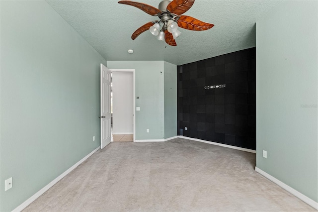 unfurnished bedroom featuring light carpet, ceiling fan, and a textured ceiling