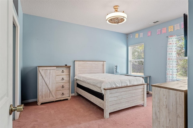 carpeted bedroom featuring a textured ceiling