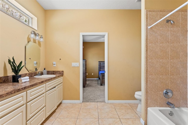 full bathroom with tiled shower / bath, tile patterned floors, toilet, and vanity