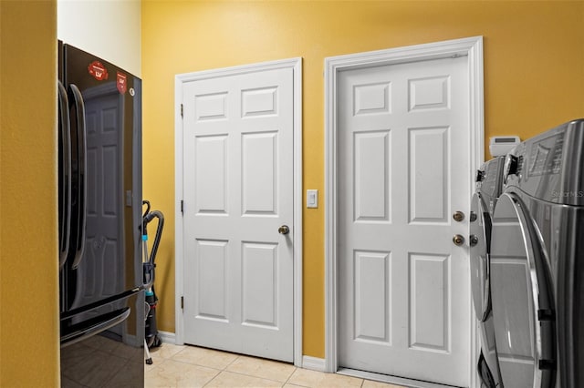 tiled entryway with washer and clothes dryer