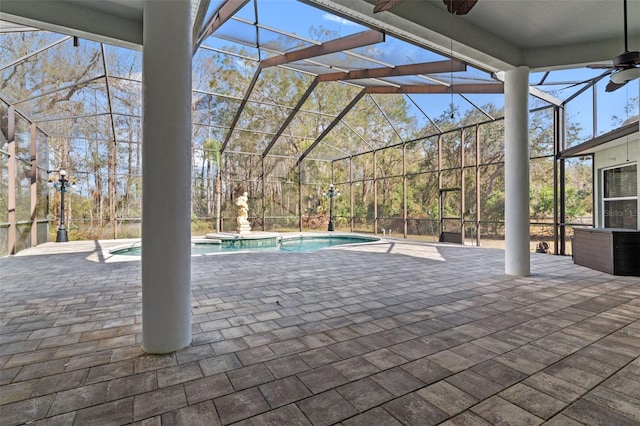 view of patio / terrace featuring a swimming pool with hot tub, ceiling fan, and glass enclosure