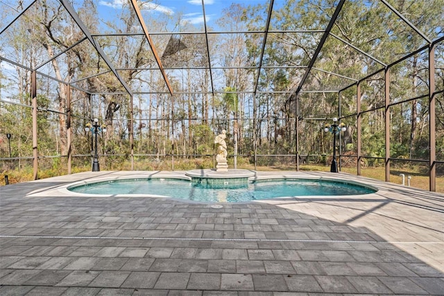 view of pool with a hot tub, glass enclosure, and a patio area