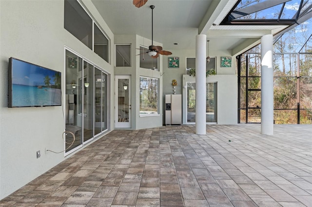 unfurnished sunroom with ceiling fan and a skylight