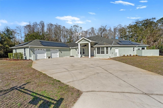 single story home featuring a garage, a front lawn, and solar panels