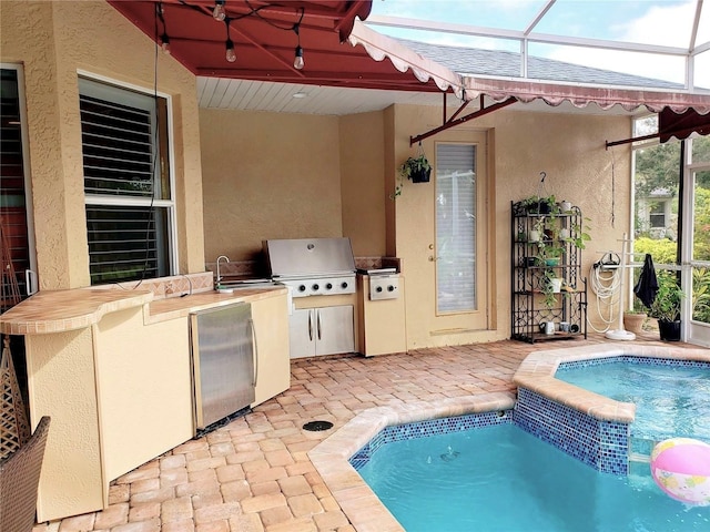 view of pool featuring a sink, a grill, an outdoor kitchen, and a patio