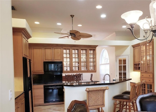 kitchen featuring a breakfast bar, backsplash, black appliances, dark countertops, and glass insert cabinets