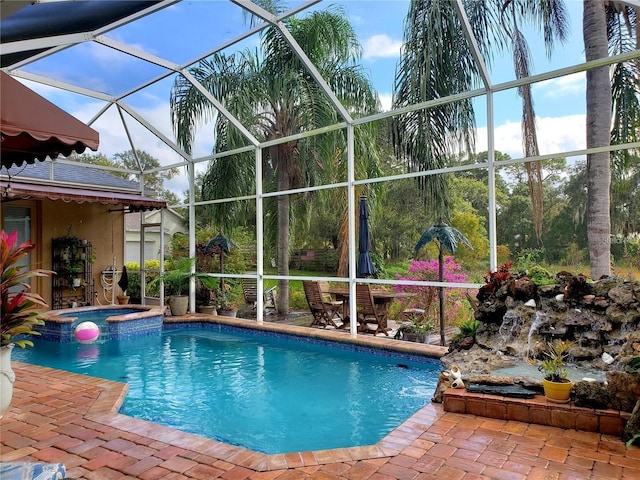 view of swimming pool with a patio area, a lanai, and a pool with connected hot tub