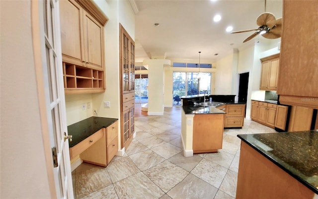 kitchen featuring ceiling fan, glass insert cabinets, a center island, hanging light fixtures, and a sink