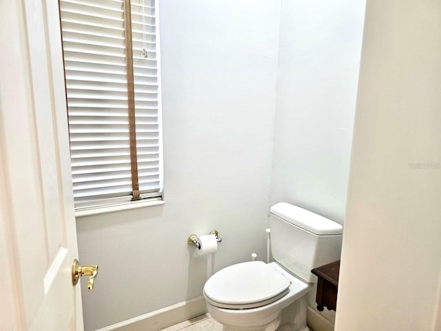 bathroom with baseboards and toilet