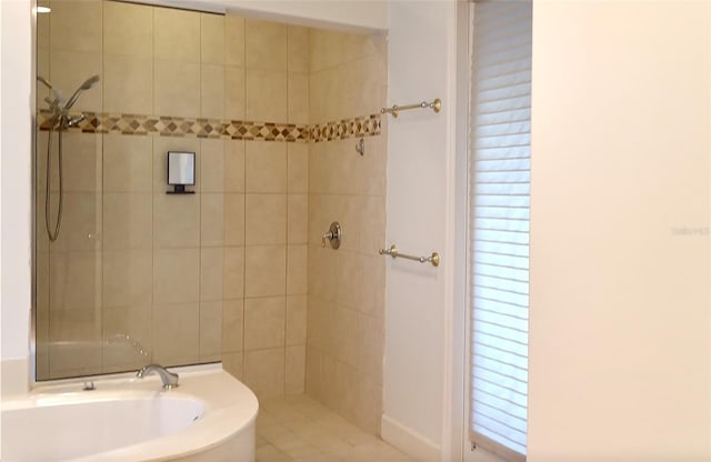 full bath with a garden tub and a tile shower