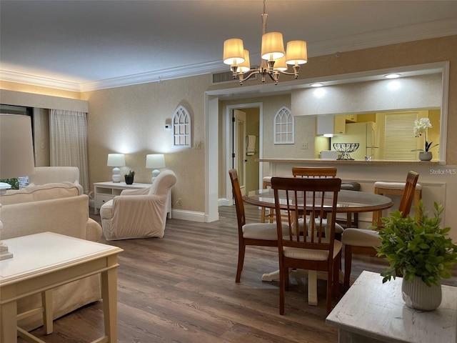 dining room featuring hardwood / wood-style flooring, ornamental molding, and a chandelier