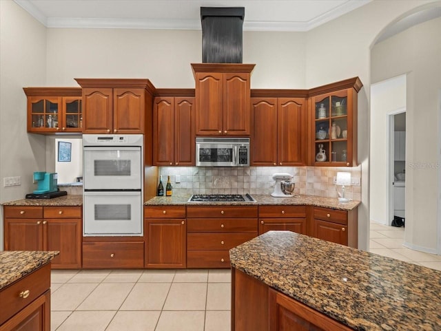 kitchen with stone counters, crown molding, appliances with stainless steel finishes, and backsplash