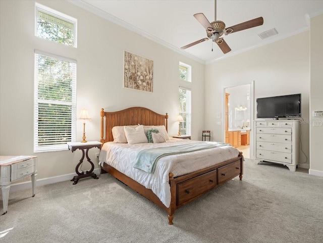 bedroom with ceiling fan, ensuite bath, ornamental molding, and light carpet