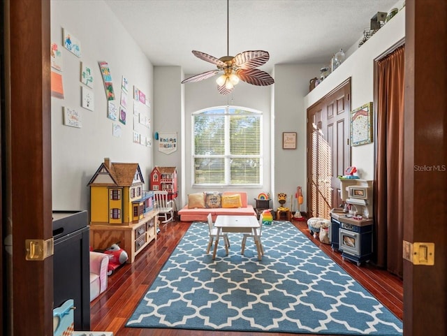 playroom with dark wood-type flooring and ceiling fan