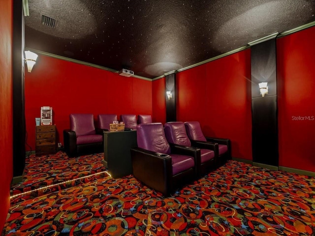 cinema room featuring ornamental molding, carpet floors, and a textured ceiling