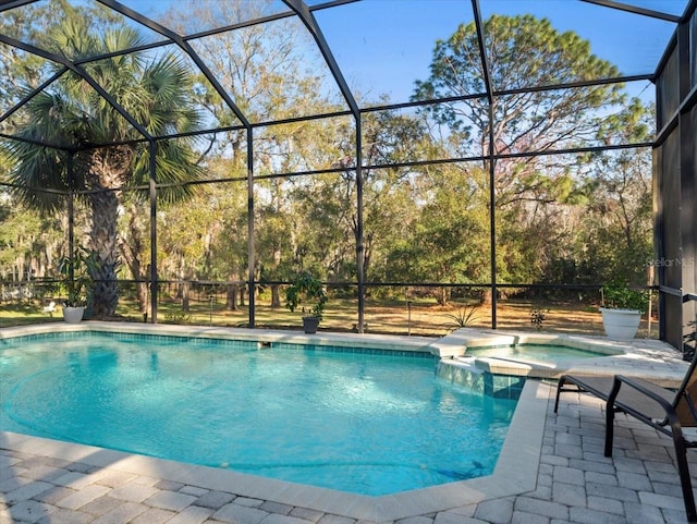 view of pool featuring an in ground hot tub, glass enclosure, and a patio area