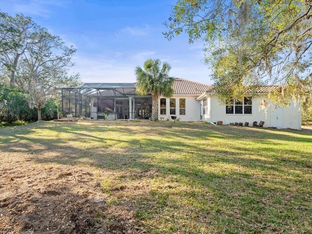 rear view of property with a lanai and a yard