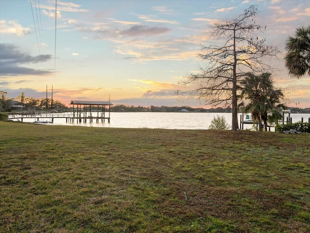 view of dock featuring a water view and a lawn