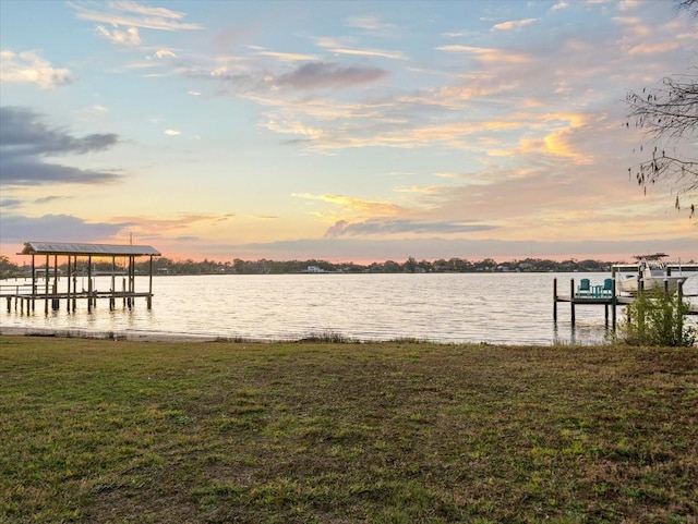 view of dock featuring a yard and a water view