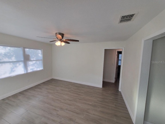 empty room with ceiling fan and hardwood / wood-style floors