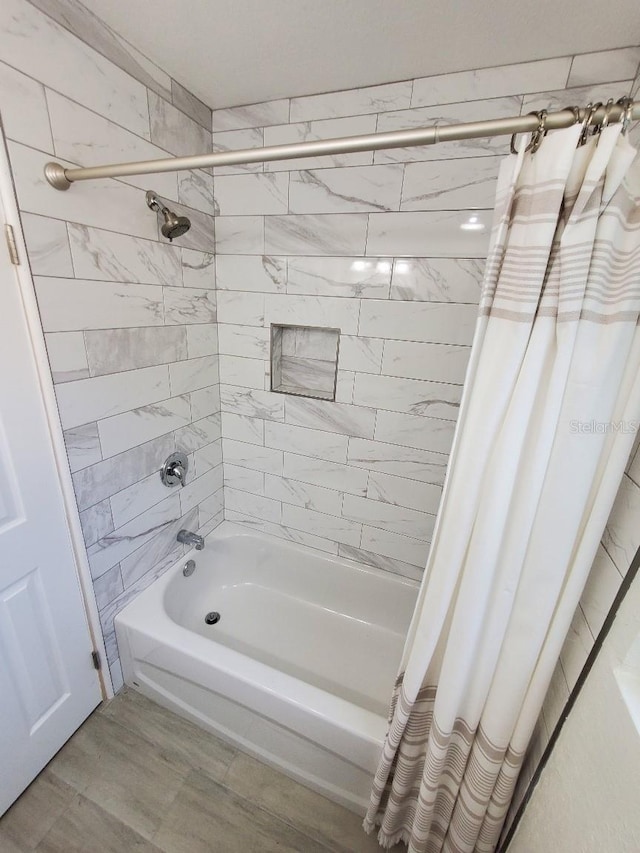 bathroom with shower / tub combo with curtain and hardwood / wood-style floors