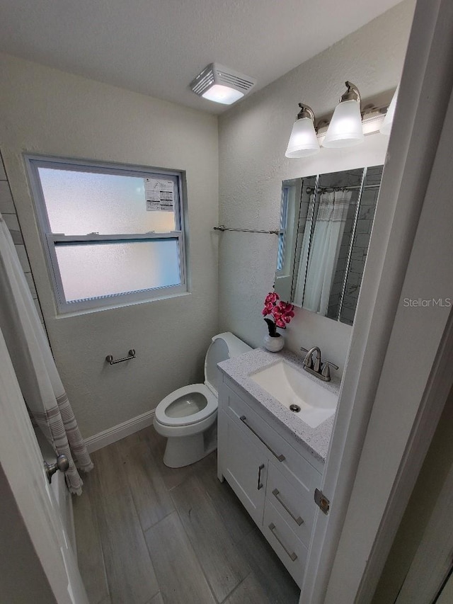 bathroom featuring vanity, toilet, and hardwood / wood-style floors