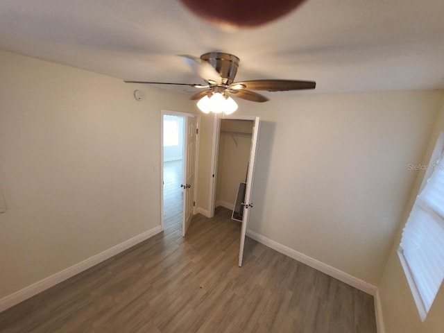 unfurnished bedroom featuring ceiling fan, dark hardwood / wood-style floors, and a closet