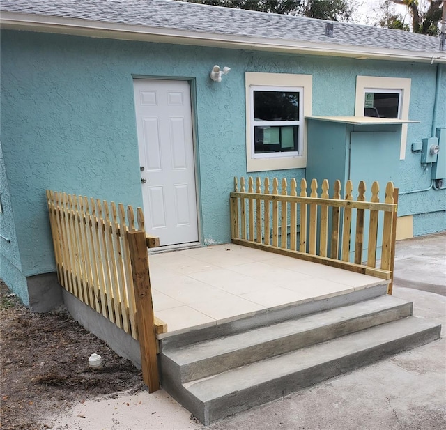 view of exterior entry with a patio area