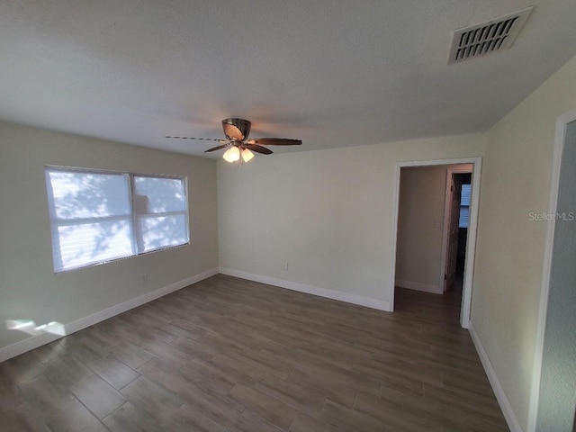 unfurnished room featuring dark hardwood / wood-style flooring and ceiling fan