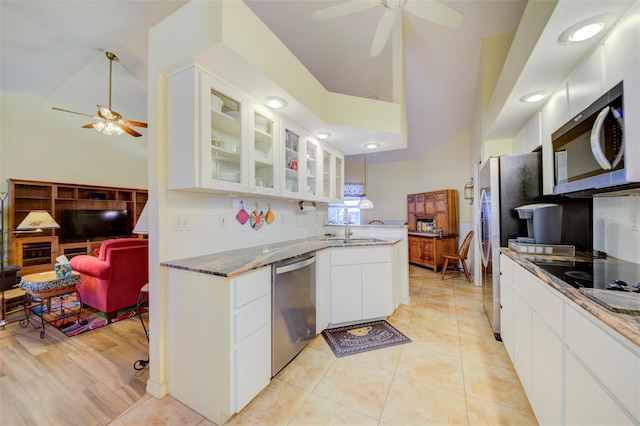 kitchen with sink, white cabinets, stone counters, stainless steel appliances, and backsplash