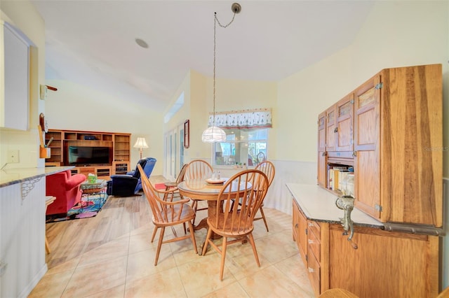 dining space with light tile patterned flooring and vaulted ceiling