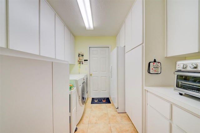 laundry room featuring light tile patterned floors, independent washer and dryer, and a textured ceiling