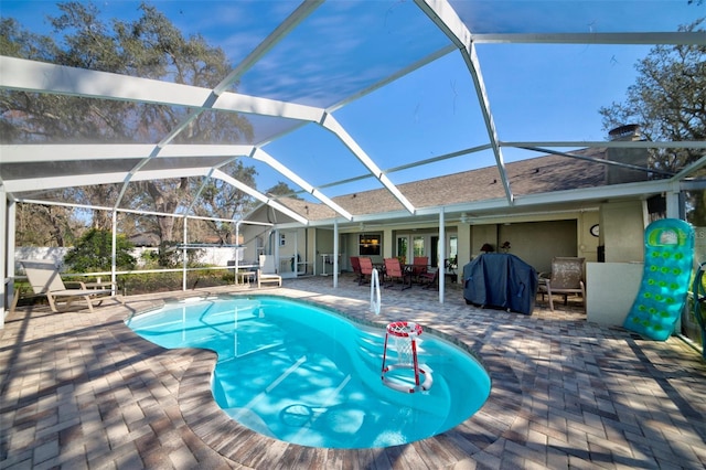 view of swimming pool with a lanai and a patio