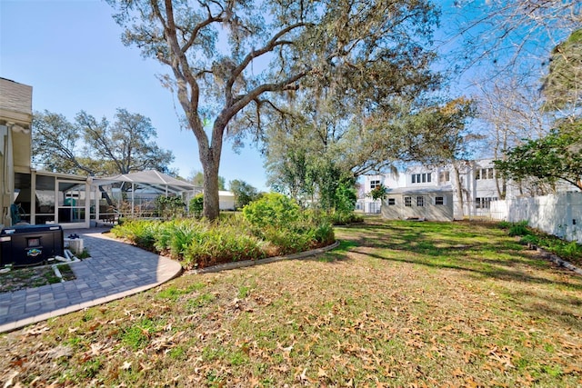 view of yard with a patio, a sunroom, and glass enclosure