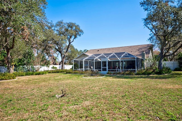 back of property featuring a lanai and a yard