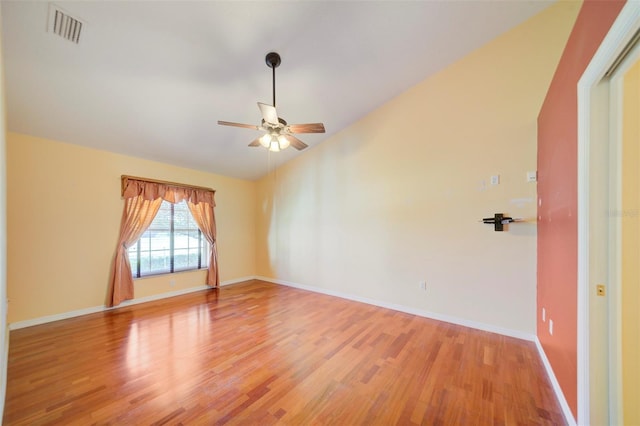 spare room featuring lofted ceiling, ceiling fan, and light wood-type flooring