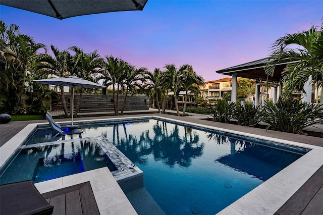 view of pool featuring a pool with connected hot tub and fence