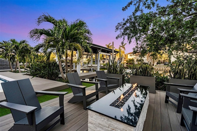 deck at dusk featuring an outdoor fire pit